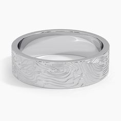 a white gold wedding band with an intricate carved design on the outside and inside side