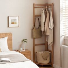 a bed room with a neatly made bed and a wooden shelf next to the bed