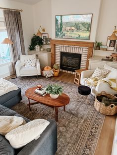 a living room filled with furniture and a fire place under a painting on the wall