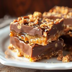 pieces of chocolate and nuts are stacked on top of each other in the middle of a plate