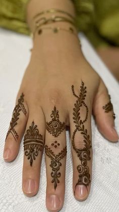 a woman's hand with henna tattoos on it