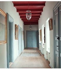 an empty hallway with blue doors and red ceiling