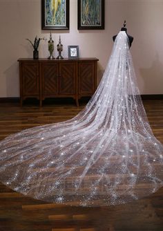 a white wedding veil on a mannequin in front of a wall with pictures