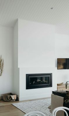 a living room filled with furniture and a fire place next to a wall mounted tv