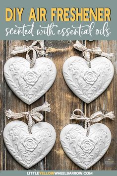 three white heart shaped ornaments hanging on a wooden wall with text overlay that says diy air freshener scented with essential oils