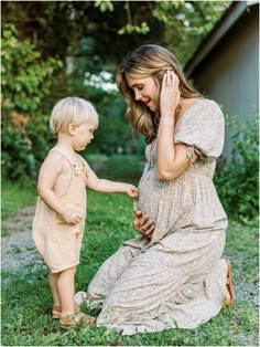 a mother and her son playing with each other in the grass