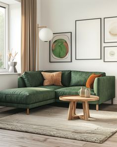 a living room with green couches and pictures on the wall above it, along with a round coffee table