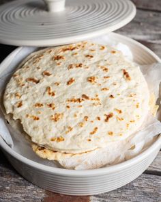 two white plates with food on them sitting on a wooden table next to each other