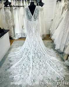 a white wedding dress on display in a bridal room with other dresses and gowns