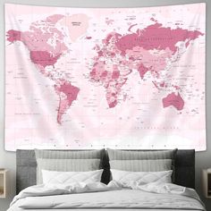 a bed with a pink world map hanging on the wall