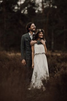 a man and woman standing in tall grass