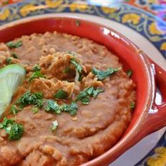 a red bowl filled with food and garnished with cilantro on top