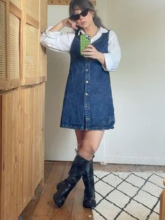 Denim pinafore dress, white linen button up and black knee high boots outfit inspo Button Up Under Dress Outfit, Denim Dress Work Outfit, Knee Boots Outfit Summer, Turtleneck And Dress Outfit, Boxy Dress Outfit, Aline Outfits, Autumn Dress Outfit Casual, Fall Denim Dress Outfit, Knee High Boots Outfit Midsize