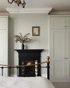 a bedroom with a bed, fireplace and closets in the wall next to it