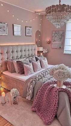 a bedroom with a large bed, chandelier and pictures on the wall above it