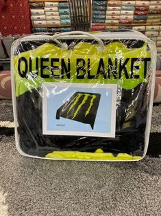 a bag with the words queen blanket on it in front of some bookshelves