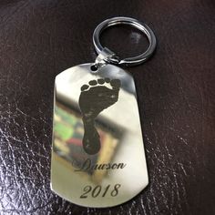 a dog tag with a hand and foot imprint on it