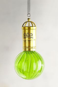 a green glass ornament hanging from a wire