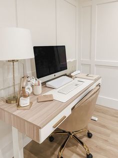 a desk with a computer, lamp and other office supplies on it in a white room