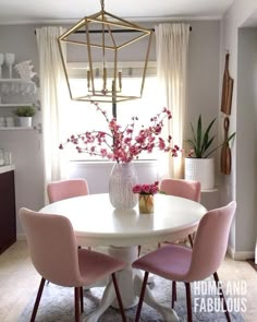 a white table with four pink chairs around it