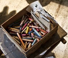 a box filled with crayons sitting on top of a wooden table