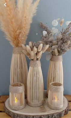 three vases with flowers in them sitting on a table