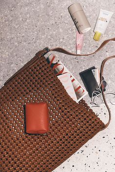 a brown purse sitting on top of a floor next to other items