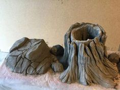 a clay sculpture of a tree stump and rocks