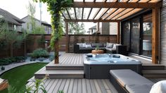 a hot tub sitting on top of a wooden deck next to a lush green yard