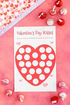 valentine's day kisses printable on pink paper surrounded by chocolates and candy