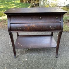 an old wooden table with two drawers on one side and another drawer on the other