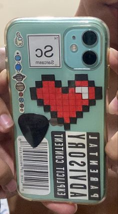 a person holding up a cell phone case with an image of a heart on it