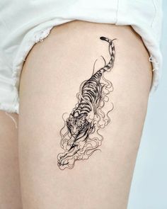 a woman's thigh with a tiger tattoo on it