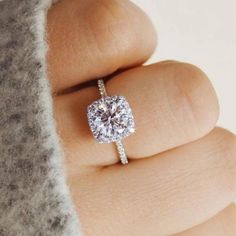 a woman's hand with a diamond ring on top of her finger and an engagement band