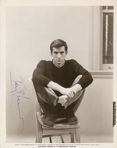 a man sitting on top of a wooden chair