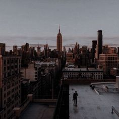 two people standing on the roof of a building in new york city at sunset or dawn