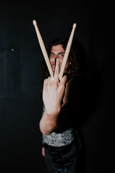 a man holding two sticks in front of his face