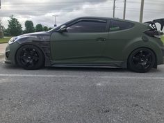 a green sports car is parked on the street