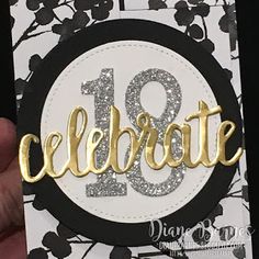 someone is holding up a card with the word celebrate in gold and silver glitters