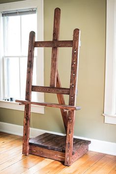 a wooden chair sitting in front of a window on top of a hard wood floor