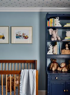 a baby's room with blue walls and bookshelves