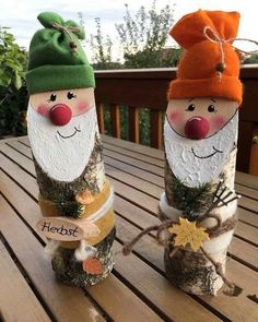 two gnomes made out of logs sitting on top of a wooden table next to each other