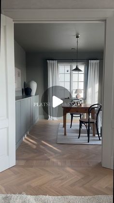 an open door leading to a dining room with a table and chairs in the center