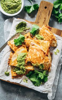 some food is laying out on a piece of parchment paper with green garnish