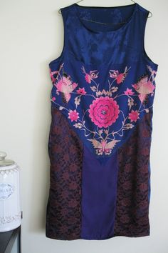 FREE SHIPPING FOR ALL US AND CANADIAN CUSTOMERS! This silk babydoll dress is designed with dark blue silk, espresso lace and a piece of vintage Miao embroidery. The Miao ethnic group in Southwest China makes exquisite embroideries. Compared to Han embroideries, Miao embroideries are wild and romantic, not afraid to use bold colors and cool contrasts. The beautiful embroidery you see features a typical pattern of a flower surrounded by a butterfly and two birds. In Miao folklore, butterfly is vie Fitted Patchwork Wedding Dress, Sleeveless Silk Dress With Lace Patchwork, Purple Silk Dresses With Floral Embroidery, Spring Wedding Patchwork Dress, Spring Wedding Dress With Patchwork, Embroidered Purple Silk Dress, Sleeveless Embroidered Silk Dress, Traditional Sleeveless Silk Dress, Vintage Blue Embroidered Dresses