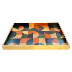 a multicolored wooden tray with circles and squares on the bottom, sitting on a white surface