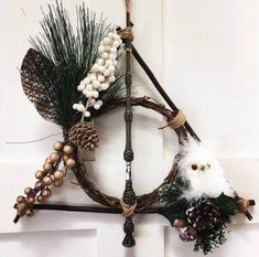 a wreath with pine cones, feathers and other decorations