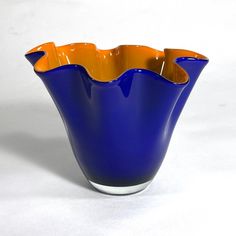 a blue and orange vase sitting on top of a white table