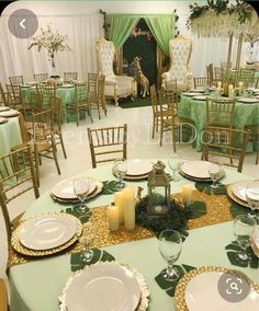 a table set up with plates, candles and place settings for an elegant dinner party