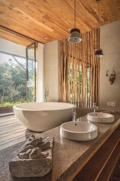 two white sinks sitting on top of a counter next to a tub in a bathroom